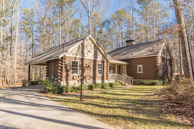 log home featuring covered porch and a front lawn