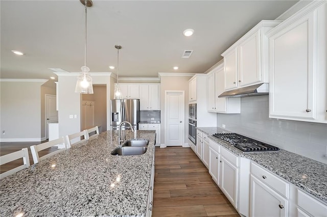 kitchen featuring decorative light fixtures, sink, white cabinetry, light stone countertops, and stainless steel appliances