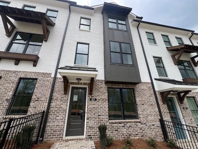 627 Silva St Unit 127, Cumming, GA 30040 - townhome / multi-family property featuring brick siding, fence, and stucco siding