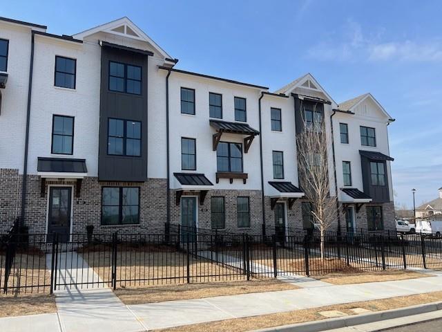 627 Silva St Unit 127, Cumming, GA 30040 - exterior space with brick siding, fence, a residential view, and a standing seam roof