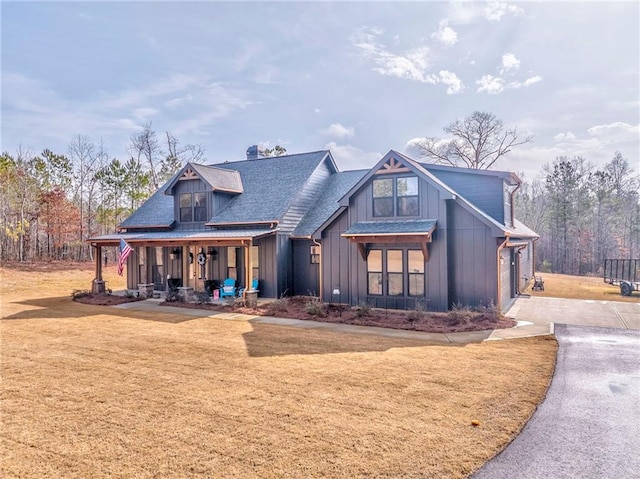 view of front facade featuring a garage, covered porch, and a front lawn