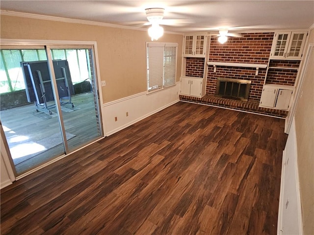 unfurnished living room featuring ornamental molding, ceiling fan, a fireplace, and dark hardwood / wood-style flooring