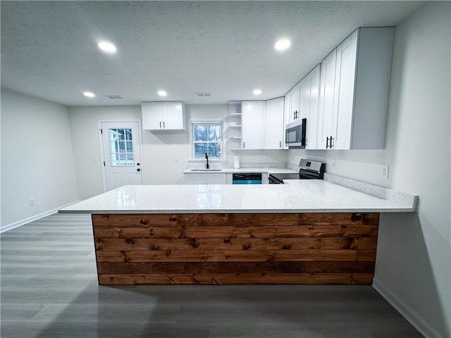 kitchen featuring kitchen peninsula, white cabinetry, sink, and appliances with stainless steel finishes