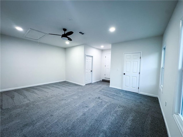 empty room with ceiling fan and dark carpet