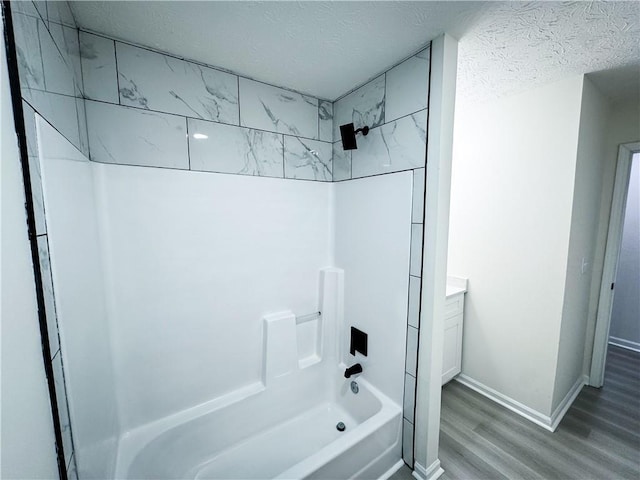 bathroom with hardwood / wood-style floors, vanity, shower / bath combination, and a textured ceiling