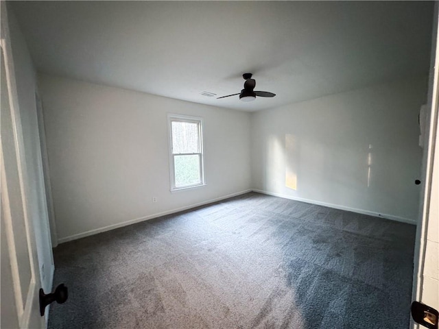 empty room with ceiling fan and dark carpet