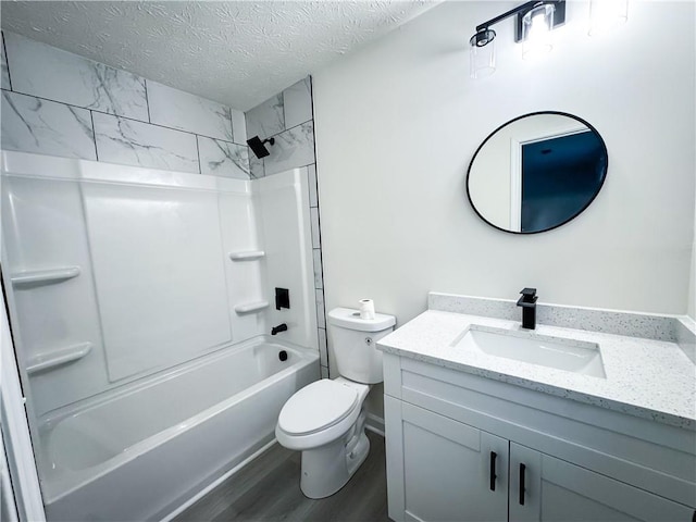 full bathroom featuring vanity, a textured ceiling, bathing tub / shower combination, hardwood / wood-style flooring, and toilet