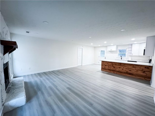 unfurnished living room with hardwood / wood-style floors and sink