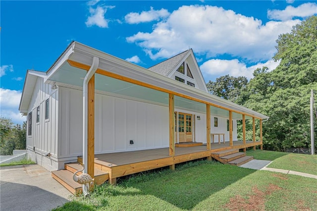 view of side of home with french doors, a yard, and board and batten siding