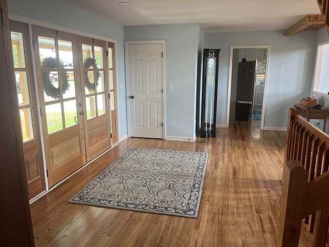 foyer with wood finished floors, french doors, and baseboards
