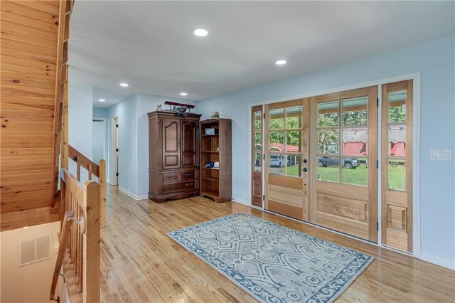 living room featuring wood ceiling, a chandelier, wood walls, high vaulted ceiling, and light hardwood / wood-style flooring