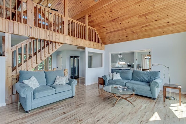living area featuring wooden ceiling, stairs, baseboards, and wood finished floors