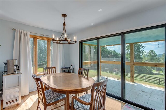 dining space with an inviting chandelier and light hardwood / wood-style flooring