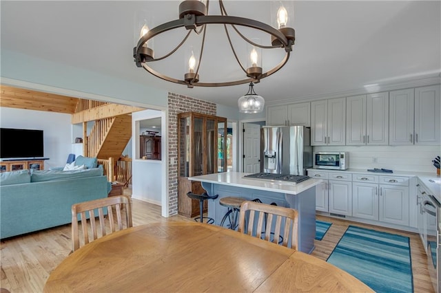dining room featuring stairs, an inviting chandelier, and light wood-style floors