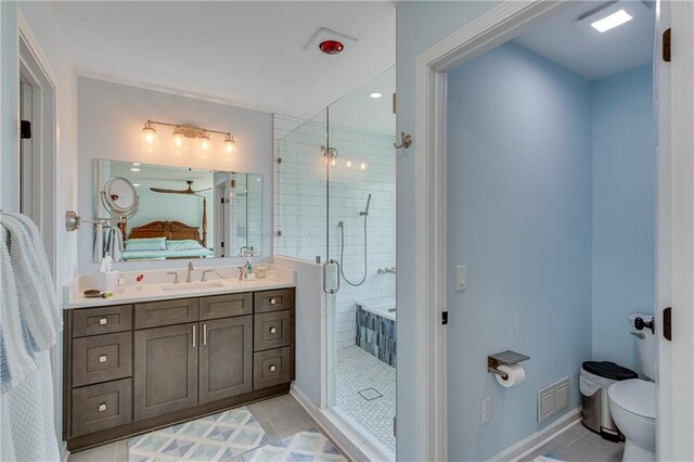 bathroom with tile patterned flooring, a shower with shower door, vanity, and toilet