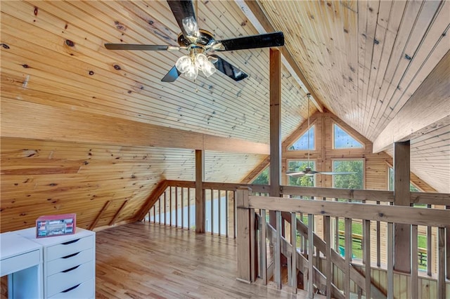 bonus room with wooden walls, wood finished floors, a ceiling fan, beam ceiling, and wood ceiling