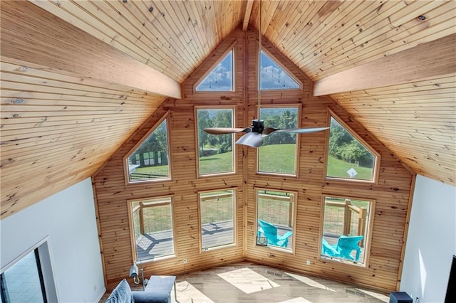 unfurnished living room featuring wooden walls and high vaulted ceiling