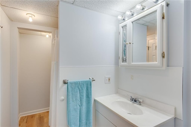bathroom featuring vanity, wood finished floors, and a paneled ceiling