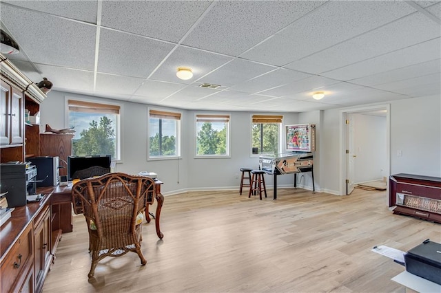 office area with visible vents, baseboards, a paneled ceiling, and light wood-style floors