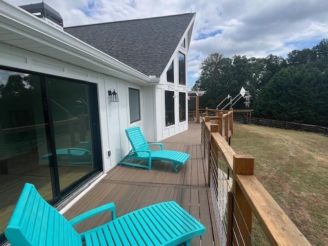 wooden terrace featuring a lawn