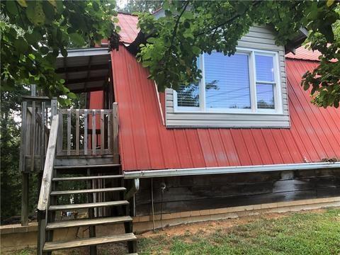 view of side of property featuring stairway and metal roof