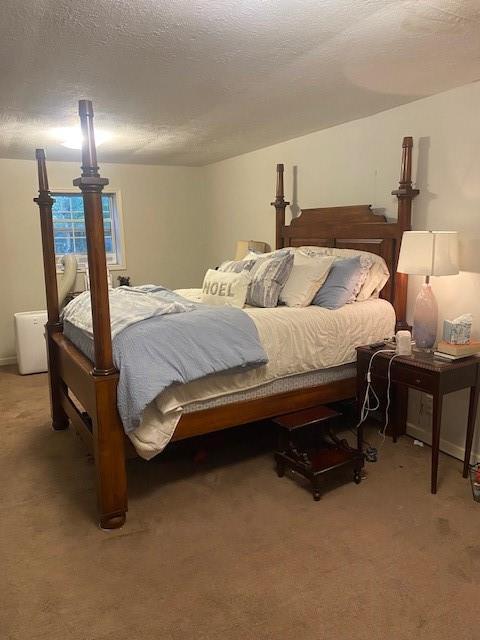 bedroom featuring light carpet and a textured ceiling