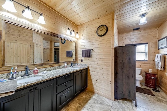 full bath with wooden walls, wooden ceiling, toilet, and a sink