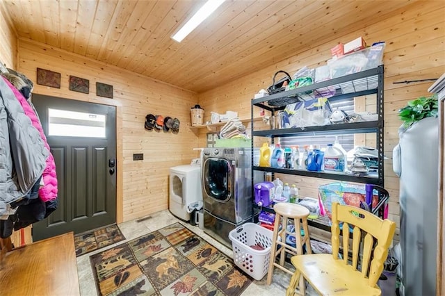 laundry room with laundry area, wood ceiling, wooden walls, and washing machine and dryer