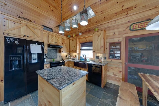 kitchen with black appliances, light brown cabinets, under cabinet range hood, a sink, and dark stone counters