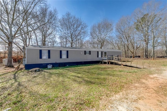 manufactured / mobile home with a wooden deck and a front yard