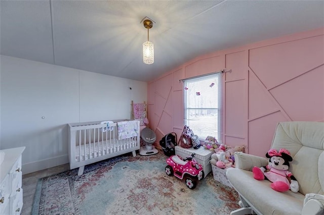 unfurnished bedroom featuring a decorative wall and lofted ceiling