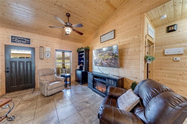 tiled living room featuring a glass covered fireplace, wood walls, wooden ceiling, and ceiling fan