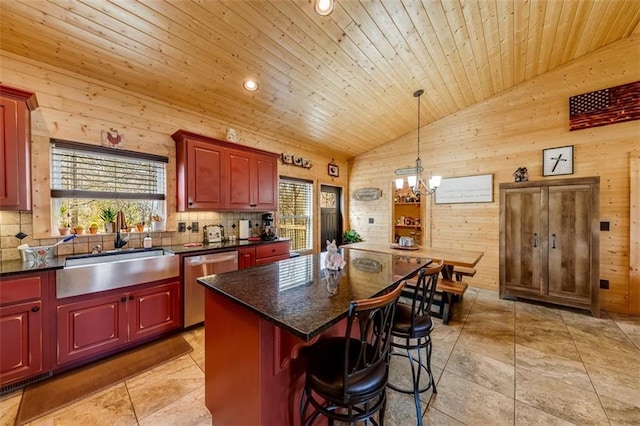 kitchen with plenty of natural light, wood walls, dishwasher, and a sink