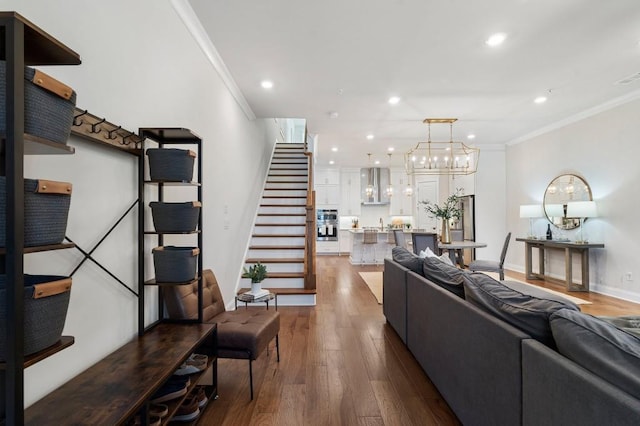 living room featuring an inviting chandelier, crown molding, and dark hardwood / wood-style floors