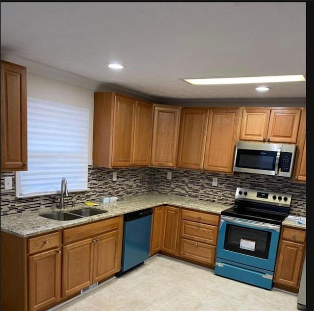 kitchen with light stone countertops, stainless steel appliances, tasteful backsplash, and sink