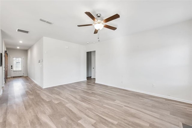 empty room with ceiling fan and light hardwood / wood-style flooring