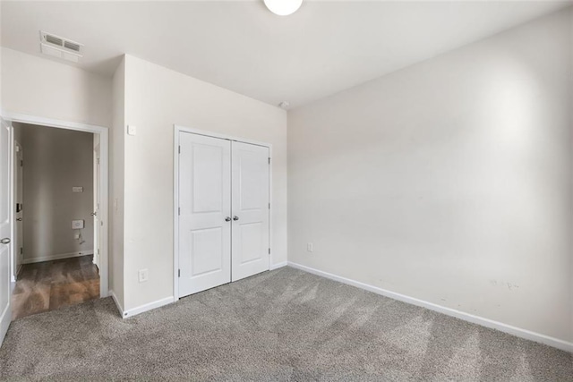 unfurnished bedroom with a closet and carpet flooring