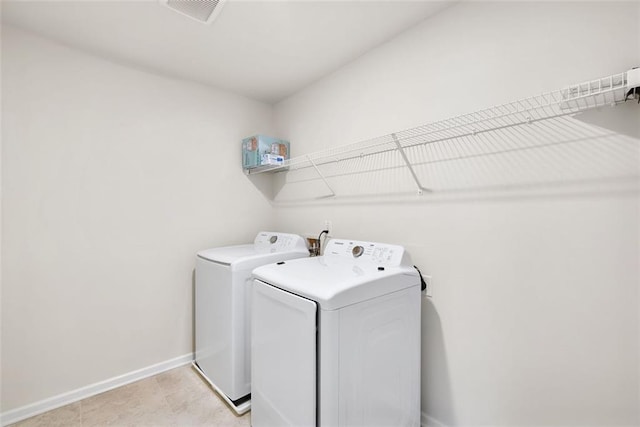 washroom with washer and clothes dryer and light tile patterned floors