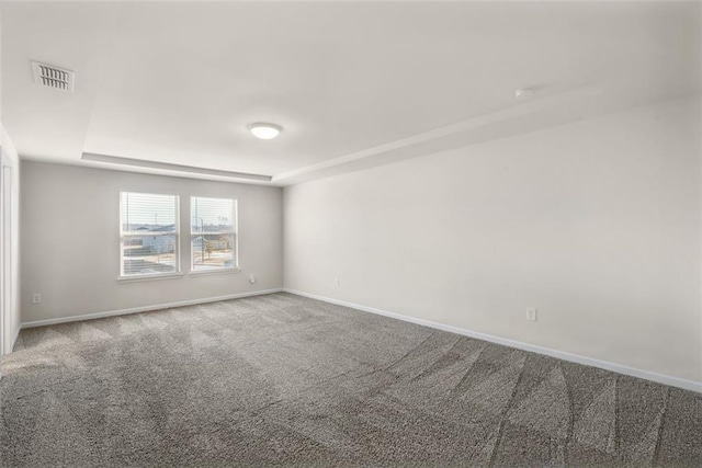 carpeted spare room with a tray ceiling