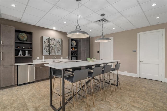 kitchen with sink, fridge, light hardwood / wood-style floors, and pendant lighting