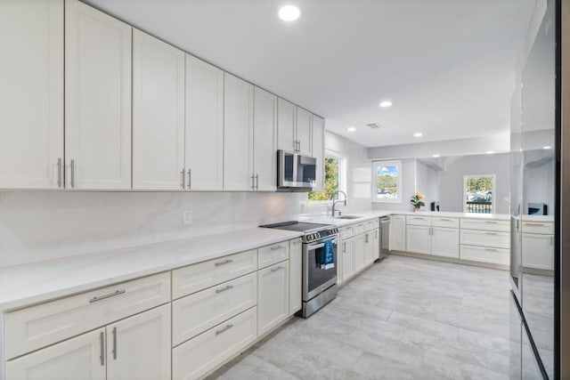 kitchen with appliances with stainless steel finishes, sink, and white cabinets