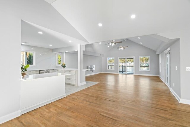 unfurnished living room with a wealth of natural light, lofted ceiling, and light hardwood / wood-style floors