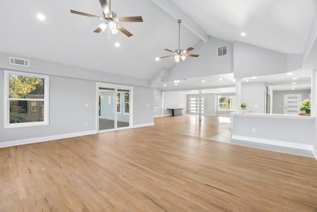 unfurnished living room featuring light hardwood / wood-style floors, beamed ceiling, and a healthy amount of sunlight