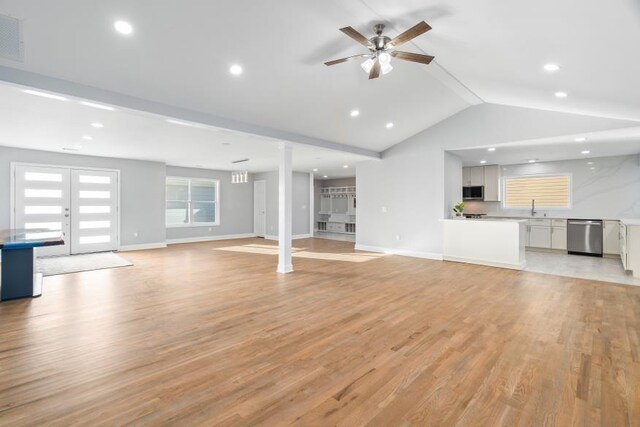 unfurnished living room featuring french doors, vaulted ceiling with beams, sink, ceiling fan, and light hardwood / wood-style flooring