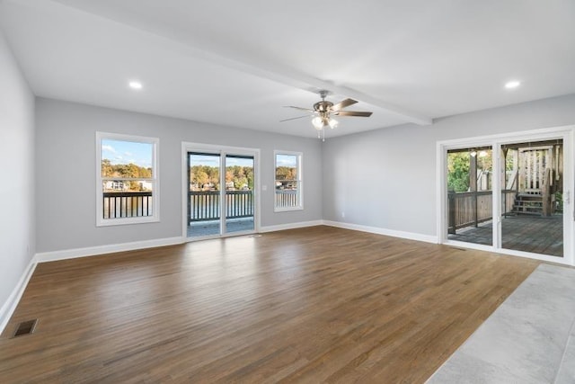 spare room with dark hardwood / wood-style flooring, ceiling fan, and beam ceiling