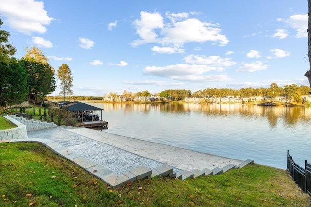 dock area with a water view and a lawn