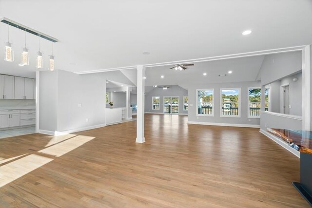 unfurnished living room featuring ceiling fan, light hardwood / wood-style flooring, and lofted ceiling