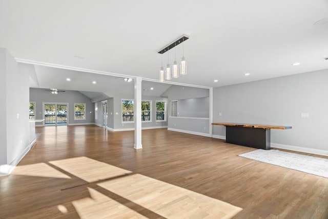 exercise area with a wealth of natural light, wood-type flooring, and vaulted ceiling