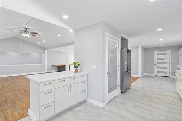 kitchen with white cabinetry, stainless steel refrigerator with ice dispenser, ceiling fan, and kitchen peninsula