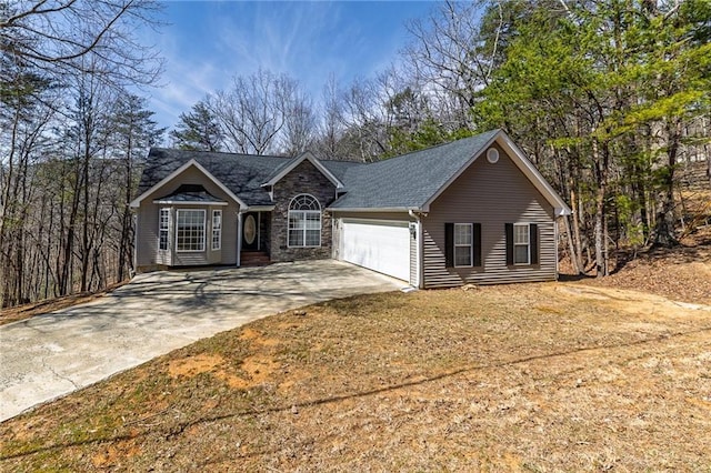 ranch-style home with a garage, stone siding, and driveway